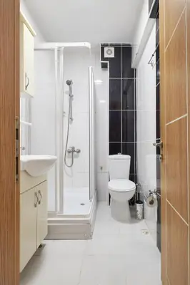 a white bathroom with a shower and a toilet at Central Suites Taksim in Istanbul