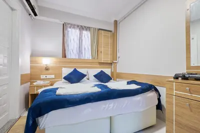 a bedroom with a bed with blue and white pillows at Central Suites Taksim in Istanbul