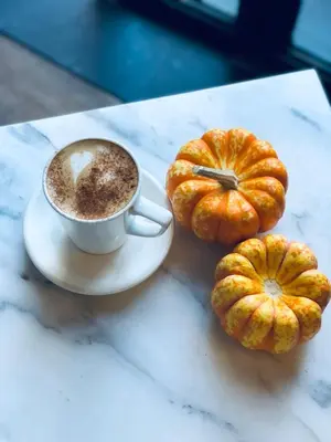 a cup of coffee and two pumpkins on a table at Le Banc in Istanbul