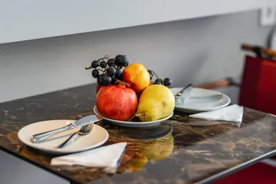 a bowl of fruit on a table with plates at Gloria Suites Old City in Istanbul
