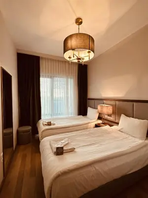 a hotel room with two beds and a chandelier at Maslak Aparts in Istanbul