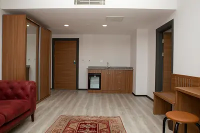 a living room with a red couch and a kitchen at BUSINESS EXPRESS HOTEL in Tekirdag