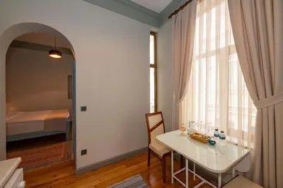 a dining room with a white table and a bed at O'Pera Okanlı Suites in Istanbul