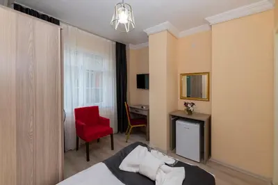a hotel room with a bed and a red chair at Avrupa Palace Hotel in Avcılar