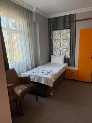 a small bedroom with a bed and a chair at Avrupa Palace Hotel in Avcılar