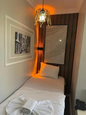 a bedroom with a bed with a light and a lamp at Avrupa Palace Hotel in Avcılar