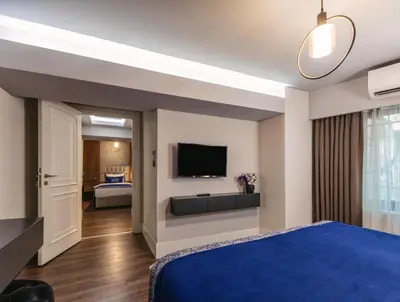a hotel room with a blue bed and a flat screen tv at Union Hotel Port in Istanbul