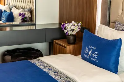 a bedroom with a blue pillow and flowers on a bed at Union Hotel Port in Istanbul