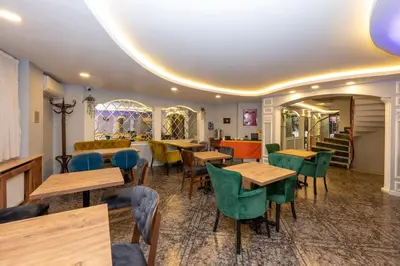 a restaurant with wooden tables and green chairs at The Hotel Devman & Terrace in Istanbul