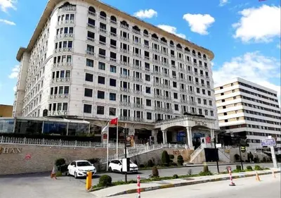 a large white building with cars parked in front of it at Doğan Palas Suites in Istanbul