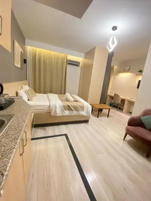 a bedroom with a bed and a living room with a kitchen at Doğan Palas Suites in Istanbul