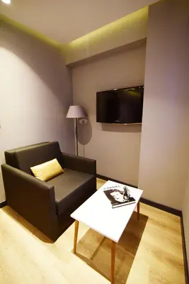a living room with a black couch and a table at The Row Taksim Hotel in Istanbul