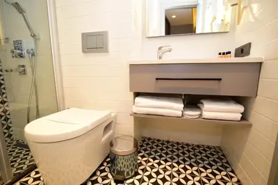 a bathroom with a toilet and a sink and a mirror at The Row Taksim Hotel in Istanbul