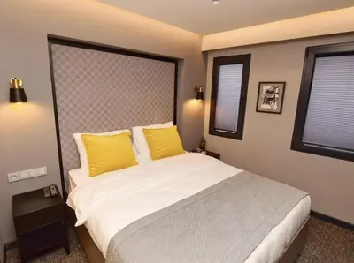 a bedroom with a large bed with yellow pillows at The Row Taksim Hotel in Istanbul