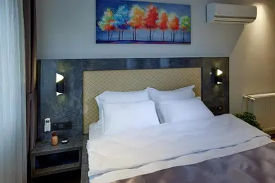 a bedroom with a white bed with a painting on the wall at The Bold Hotel in Istanbul