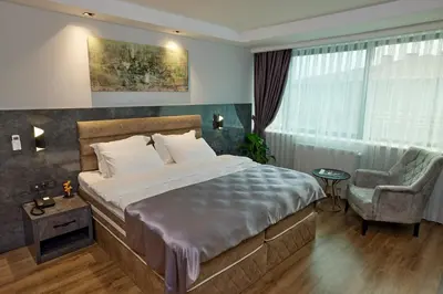 a bedroom with a bed and a chair and a window at The Bold Hotel in Istanbul