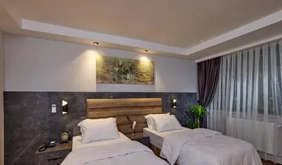 a bedroom with two beds and a painting on the wall at The Bold Hotel in Istanbul