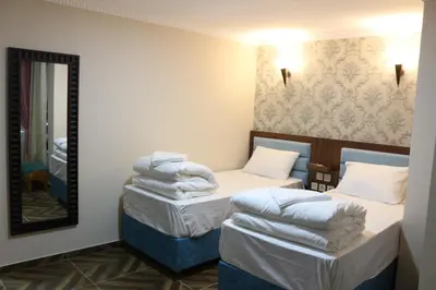 a hotel room with two beds and a mirror at HOTEL ÜMİT YENİKAPI in Istanbul