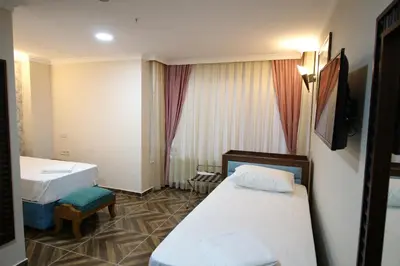 a hotel room with two beds and a television at HOTEL ÜMİT YENİKAPI in Istanbul