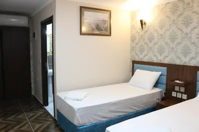 a small room with two beds and a picture on the wall at HOTEL ÜMİT YENİKAPI in Istanbul
