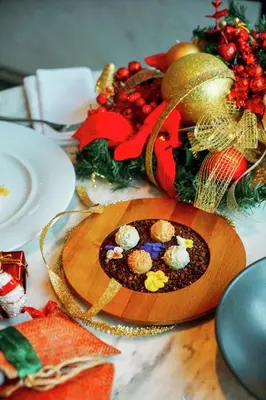 a wooden plate of food on a table with christmas decorations at Hilton Istanbul Bomonti in Istanbul