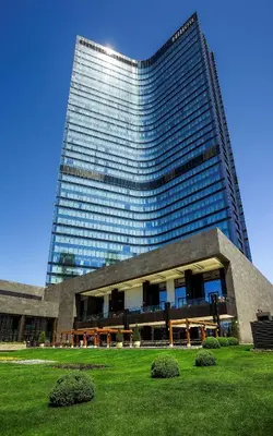 a large building with a green field in front of it at Hilton Istanbul Bomonti in Istanbul