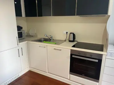 a small kitchen with white cabinets and a sink at Cosy Studio Flat -One Room in a new residence near Taksim in Istanbul