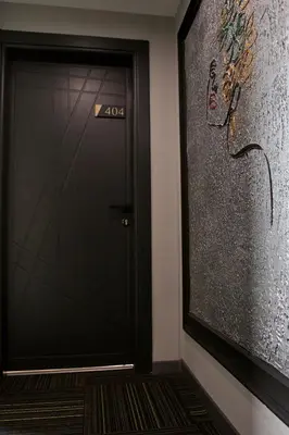 a black door with a sign on it next to a wall at Fly And Stay Airport Hotel in Istanbul