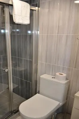 a bathroom with a toilet and a glass shower at Rodion Hotel in Istanbul