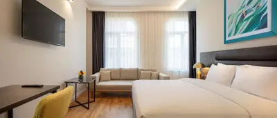 a hotel room with a bed and a couch and a tv at The Rooms Nisantasi in Istanbul