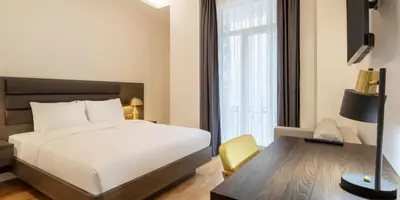 a bedroom with a white bed and a desk and a window at The Rooms Nisantasi in Istanbul