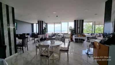 a dining room with tables and chairs and windows at VESTA RESORT BUTİK HOTEL in Istanbul
