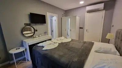 a bedroom with a bed and a vanity with a mirror at VESTA RESORT BUTİK HOTEL in Istanbul