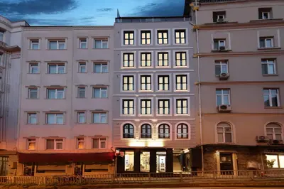 a tall white building with lights on at Walton Gardens Pera in Istanbul