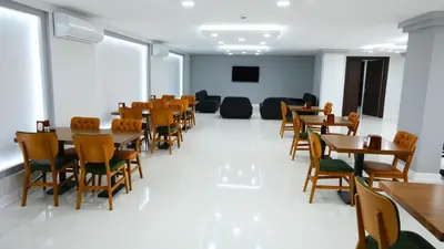a room with tables and chairs and a tv at Dimen Hotel in Bursa
