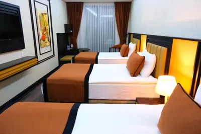 a hotel room with two beds and a flat screen tv at Dimen Hotel in Bursa