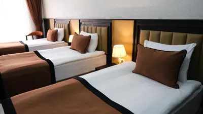 two beds in a hotel room with two at Dimen Hotel in Bursa