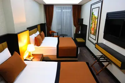 a hotel room with two beds and a flat screen tv at Dimen Hotel in Bursa