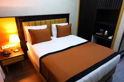 a bedroom with a large bed with pillows at Dimen Hotel in Bursa
