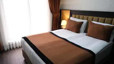 a bedroom with a large bed with a large window at Dimen Hotel in Bursa