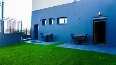 a blue building with chairs and a table in a yard at Selini Hotel İstanbul Airport in Istanbul