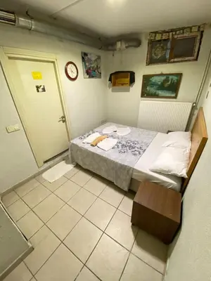 a small bedroom with a bed and a clock on the wall at GRAND BELLA VİSTA Hostel in Istanbul