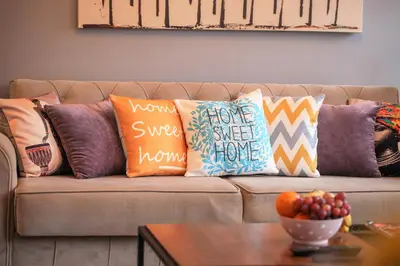 a couch with pillows on it with a table at Taksim Roya Apartment -center of the Istanbul in Istanbul