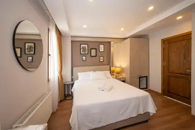 a bedroom with a white bed and a mirror at Taksim suıte in Istanbul