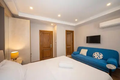 a room with a bed and a blue couch at Taksim suıte in Istanbul