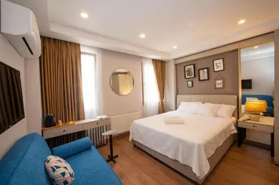 a hotel room with a bed and a blue couch at Taksim suıte in Istanbul