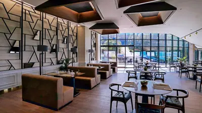 a restaurant with tables and chairs and windows at Cabir Deluxe Hotel Sapanca in Sapanca