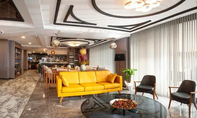 a living room with a yellow couch and a table at Hotel Bossuite Business in Istanbul