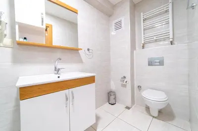 a white bathroom with a toilet and a sink at Best Hotel Pendik in Istanbul