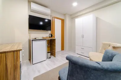 a living room with a blue chair and a kitchen at Best Hotel Pendik in Istanbul